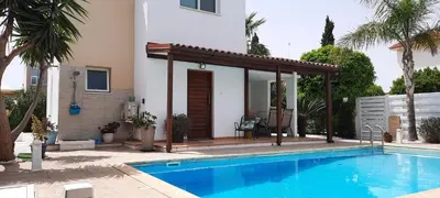 a swimming pool with a pergola next to a house at Villa Anastassia in Ayia Napa