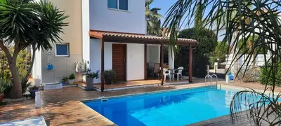 a villa with a swimming pool in front of a house at Villa Anastassia in Ayia Napa
