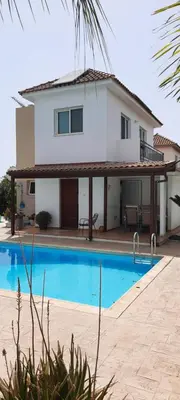a villa with a swimming pool in front of a house at Villa Anastassia in Ayia Napa