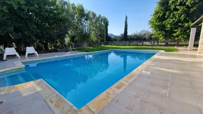 a swimming pool with two chairs in a yard at The Stone Villa in Pissouri