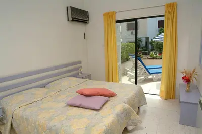 a bedroom with a bed with two pillows on it at Sunbay Apartments in Pyla