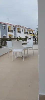 two white tables and chairs on the roof of a building at Panthoma Casa in Ayia Napa