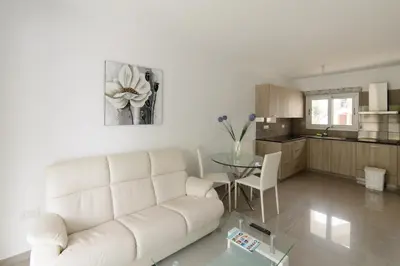 a living room with a white couch and a table at Katalimata Court in Ayia Napa