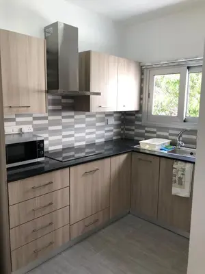 a kitchen with wooden cabinets and a black counter top at Katalimata Court in Ayia Napa