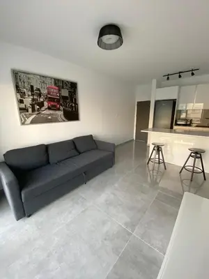 a living room with a couch and a kitchen at Greco 1 Bedroom Apartment in Limassol
