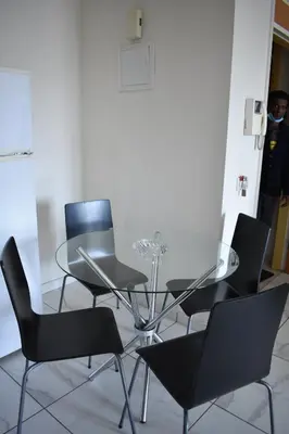 a dining room with chairs and a glass table at Klimentos Flat 59 in Nicosia