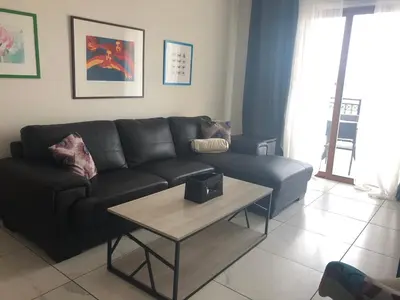 a living room with a black couch and a table at Klimentos Flat 59 in Nicosia