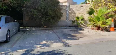 a car parked in a parking lot next to a wall at Villa Larnaca Bay Resort in Voroklini