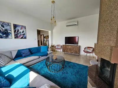 a living room with a blue couch and a fireplace at Kasparis View Residence in Pano Lefkara