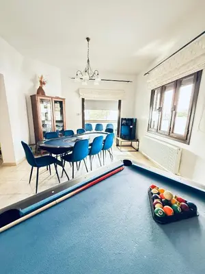 a dining room with a pool table and blue chairs at Kasparis View Residence in Pano Lefkara