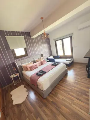 a bedroom with a large bed and a living room at Kasparis View Residence in Pano Lefkara