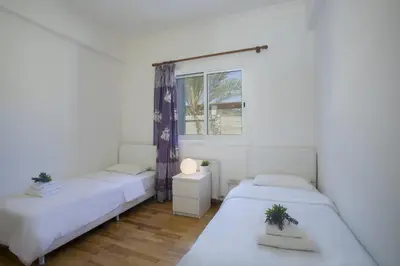 two beds in a room with a window at Protaras Villa Mazeri in Protaras