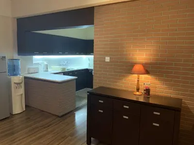 a kitchen with a brick wall and a table with a lamp at Kika Court 2 in Paralimni