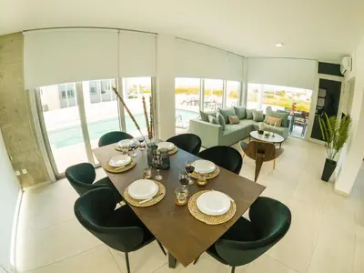 a dining room with a table and chairs and a couch at Imperial Jade Villas Gold Emerging Villas 2 in Protaras