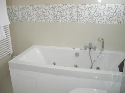 a white bath tub in a bathroom with a toilet at Crystal Hotel in Kakopetria