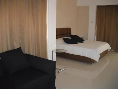 a bedroom with a bed with a chair and a couch at Crystal Hotel in Kakopetria