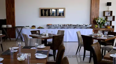 a dining room with tables and chairs and a stove at Crystal Hotel in Kakopetria