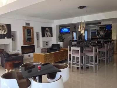 a living room with a bar and a restaurant at Crystal Hotel in Kakopetria