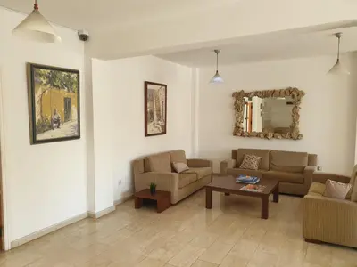 a living room with couches and a table and a mirror at Florea Hotel Apartments in Ayia Napa