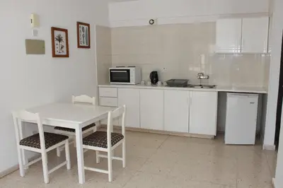 a kitchen with a table and chairs and a microwave at Florea Hotel Apartments in Ayia Napa
