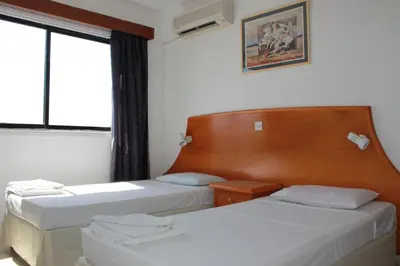 a hotel room with two beds and a window at Florea Hotel Apartments in Ayia Napa