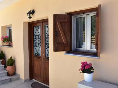 a house with a door and a window and flowers at The Old Coffeehouse in Kalopanayiotis