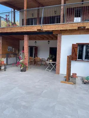 an outdoor patio with a deck and tables and chairs at The Old Coffeehouse in Kalopanayiotis