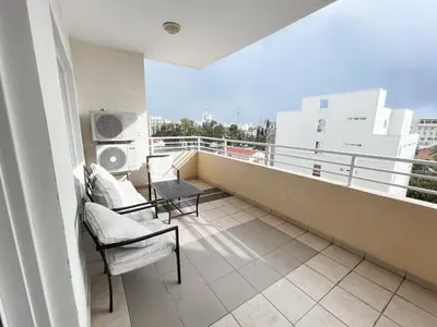 a balcony with two chairs and a table on a building at Apartment Capella, Larnaca in Larnaka