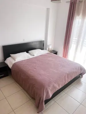 a bedroom with a large bed with a purple blanket at Apartment Capella, Larnaca in Larnaka