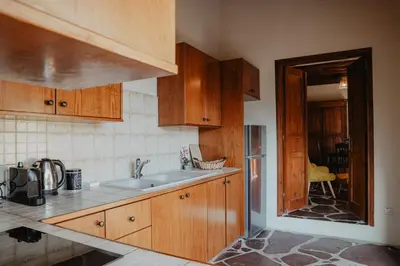 a kitchen with wooden cabinets and a sink at The Stonehouse Suites with Private Bath Spas in Limassol
