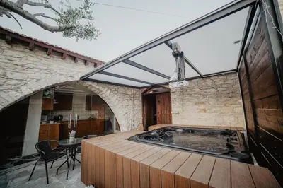 an indoor hot tub in a room with a stone wall at The Stonehouse Suites with Private Bath Spas in Limassol