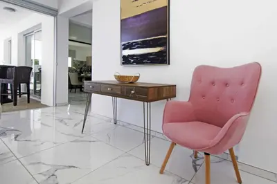 a pink chair and a table in a room at Villa Napa View in Ayia Napa