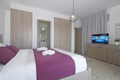 a bedroom with two towels on a bed with a tv at Villa Napa View in Ayia Napa