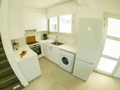a white kitchen with a washing machine in it at Imperial Jade Villas Gold Emerging Villas 1 in Protaras