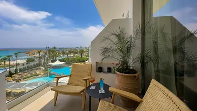 a balcony with chairs and a view of a resort at Tasia Maris Beach Hotel - Adults Only in Ayia Napa