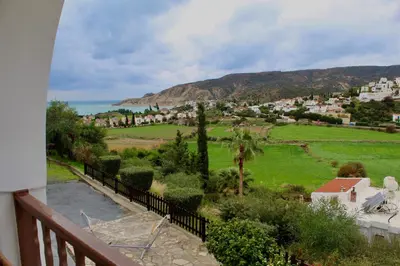 a balcony with a view of a town and the ocean at skeleas 10 in Pissouri