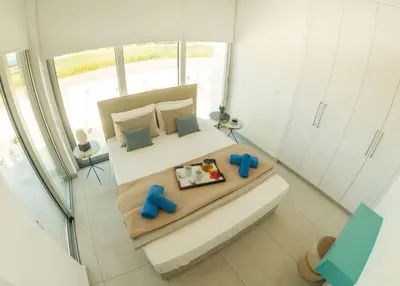 a small bedroom with a bed with blue pillows at Imperial Jade Villas Gold Emerging Villas 3 in Protaras
