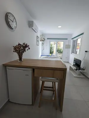 a kitchen with a desk and a clock on the wall at Modern & Cozy Studio w/ Backyard Near City Center in Limassol