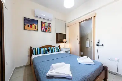 a bedroom with a blue bed with towels on it at Villa Alexandra by Ezoria Villas in Ayia Napa