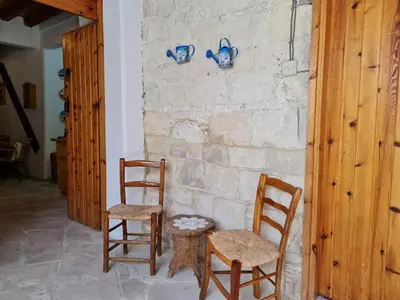 two chairs and a table next to a stone wall at Kassandras place in Omodos village in Omodos
