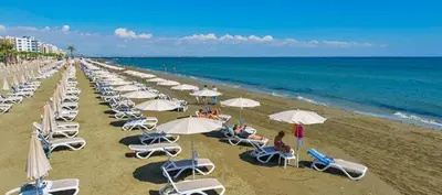 a beach with many chairs and umbrellas and the ocean at Casa Di Gio in Tersephanou
