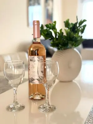 a bottle of wine and two wine glasses on a table at NISSI BEACH Apt 7 BIG VERANDA AND FREE WIFI in Ayia Napa