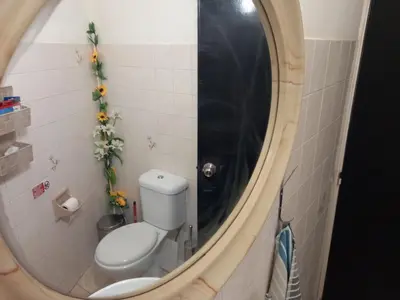 a bathroom with a toilet and a round mirror at Artemis Boutique Apartment 2 in Limassol