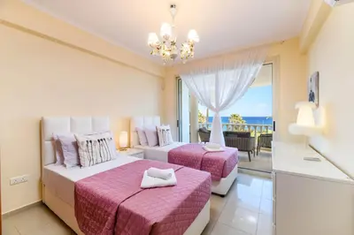 two beds in a room with a view of the ocean at Royal Beachfront Villa in Protaras