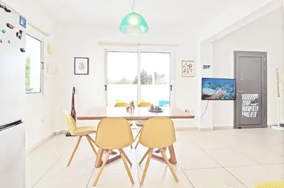 a kitchen with a dining room table and chairs at Nissini Shell, 3 bedroom villa with private pool at Nissi Beach in Ayia Napa