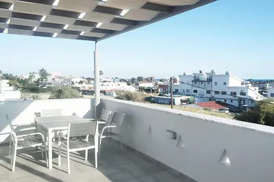 a table and chairs on a balcony with a view at Nissini Shell, 3 bedroom villa with private pool at Nissi Beach in Ayia Napa