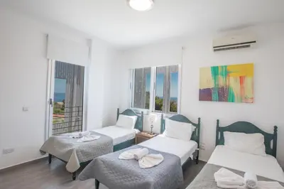 a room with two beds and a window at Chloe Luxury Villas in Protaras