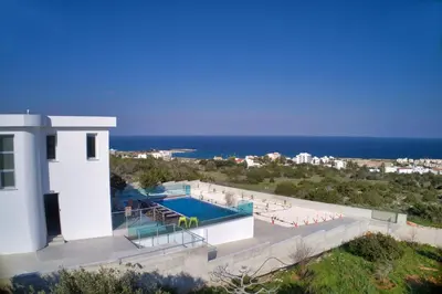 a house with a swimming pool next to the ocean at Chloe Luxury Villas in Protaras