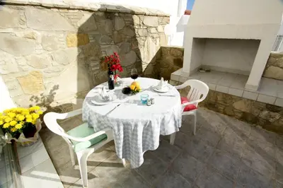 a white table and chairs on a patio at Pissouri Beach Apartments in Pissouri