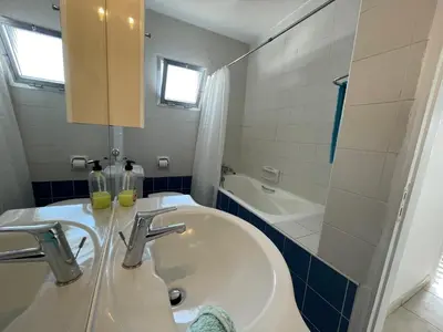 a bathroom with a sink and a bath tub at Pissouri Beach Apartments in Pissouri